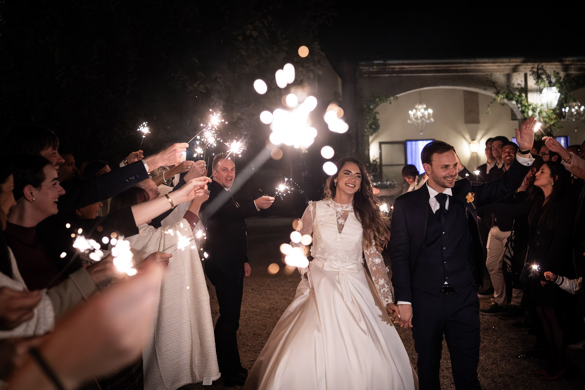 Una coppia di sposi cammina tra amici con le stelle filanti